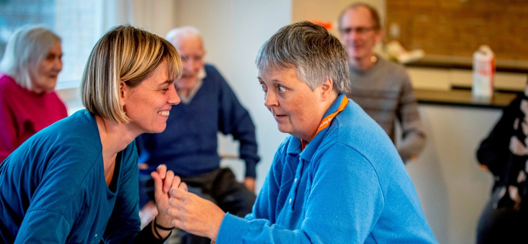 Kvinde danser med et personale, mens de kigger på hinanden