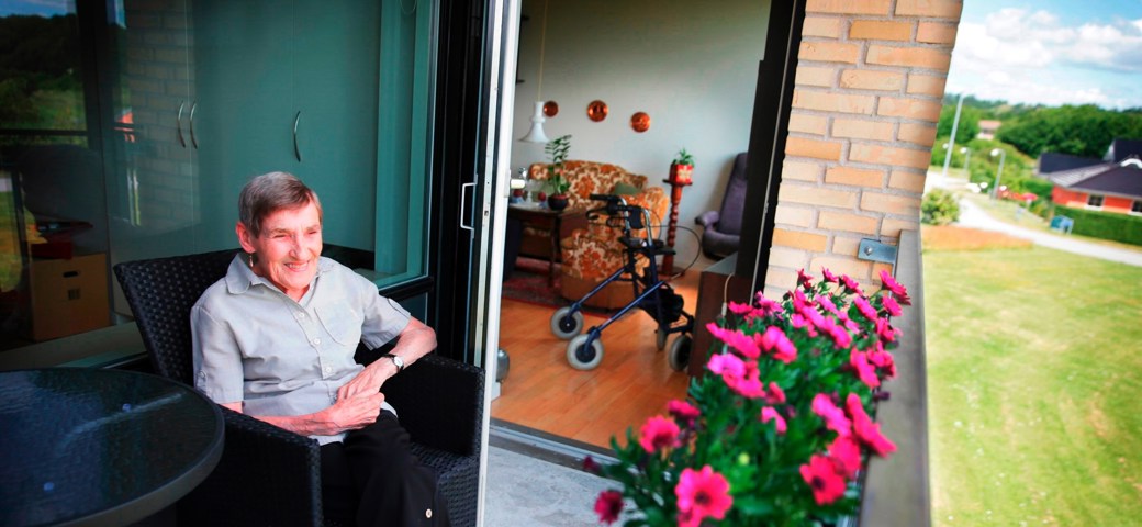 Senior kvinde sidder på altanen på Æblelunden