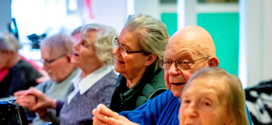 Fællesarrangement på Bakkegården, hvor der holdes i hånd og synges