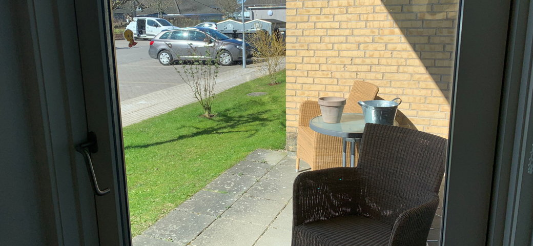 Udsigt fra en bolig på Æblelunden ud terrassen på den side der vender mod parkeringspladsen