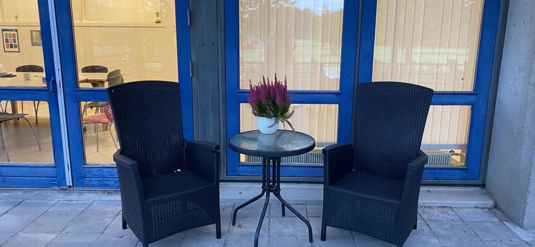 To stole ved et bord på terrassen på Birkebjergcenteret
