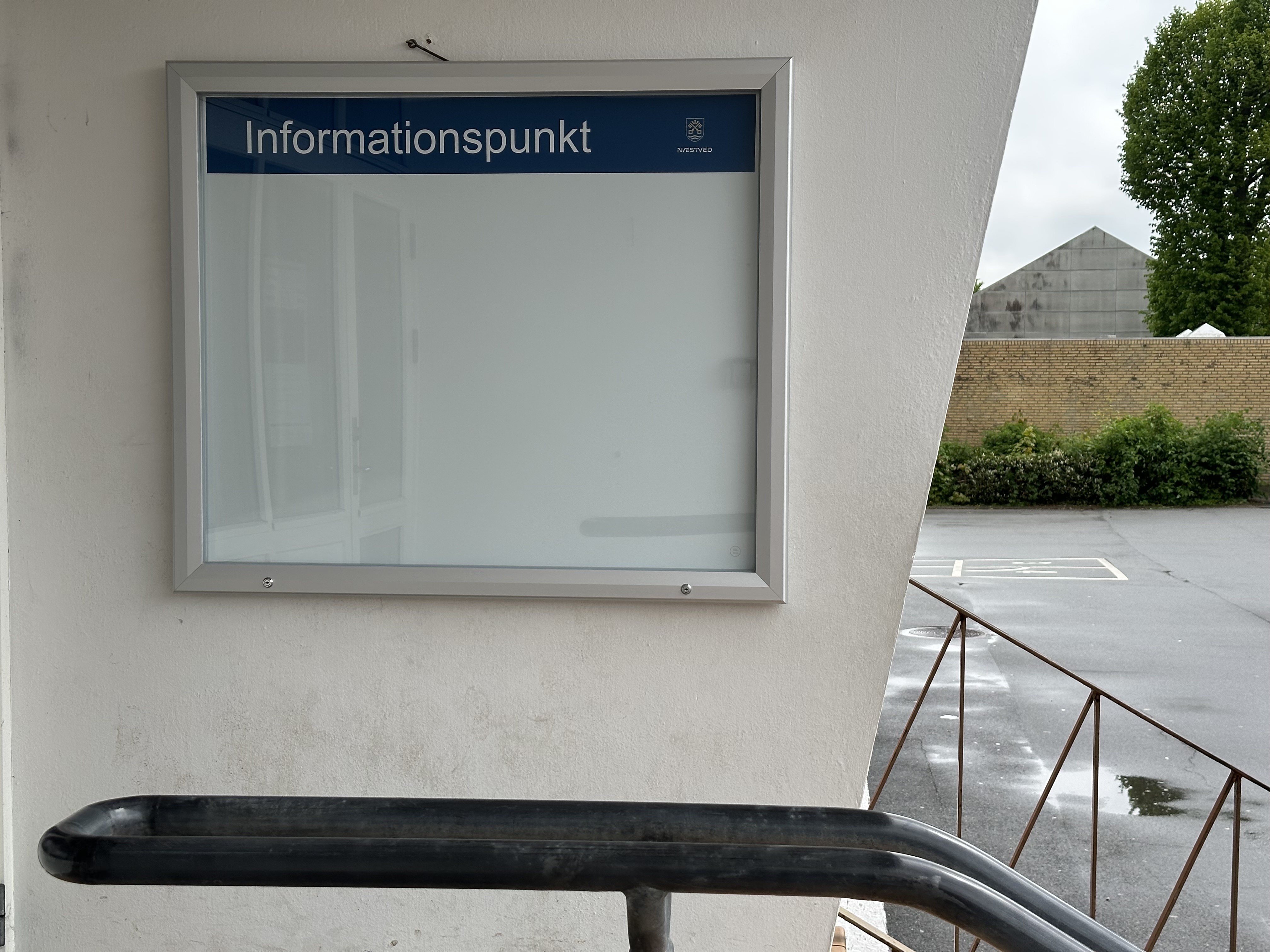 Billede af en væg, hvor der hænger en ramme med glad, hvor der står informationspunkt. 