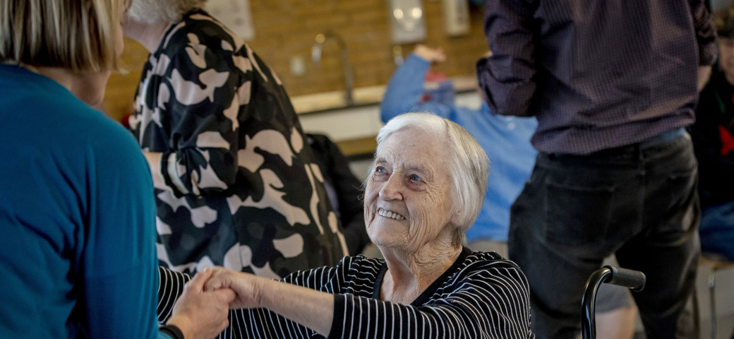 Kvinde i kørestol danser med et personale